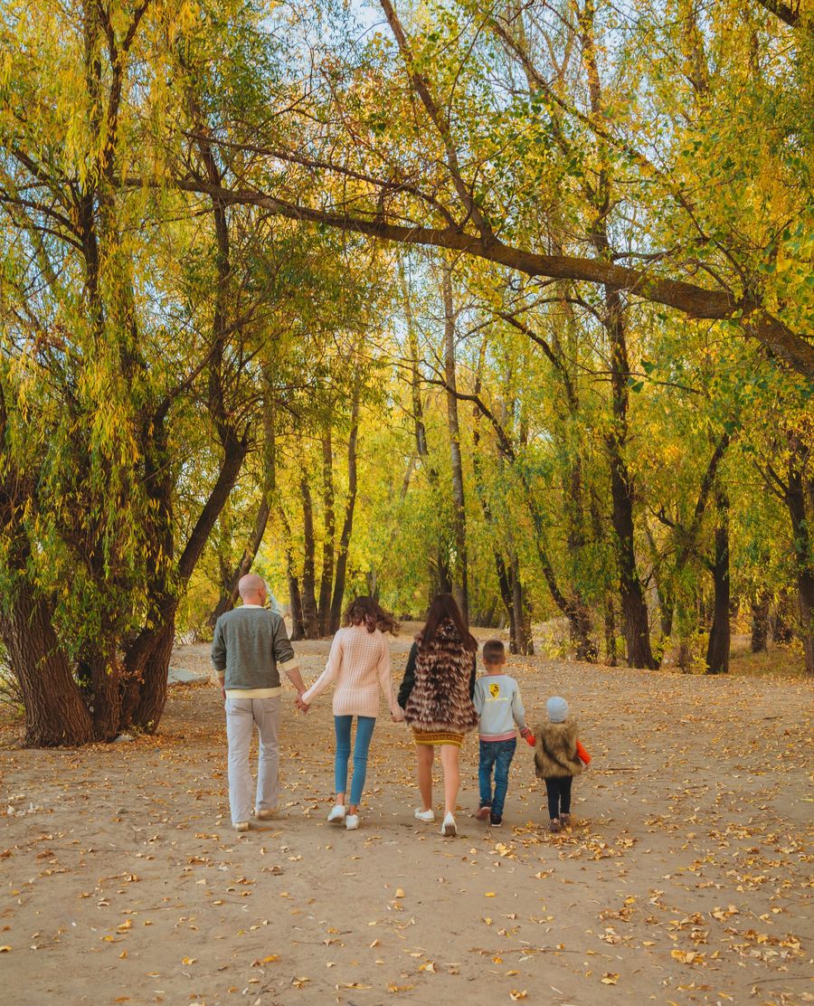 Familia paseando de la mano por un parque